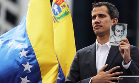 Guaido declares himself Venzuelan interim president, holding a picture of revolutionary, Simón Bolívar.