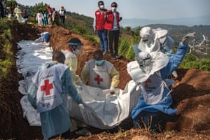 Congolese Red Cross members burying bodies in a mass grave