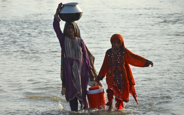 Flood affected women carry drinking water