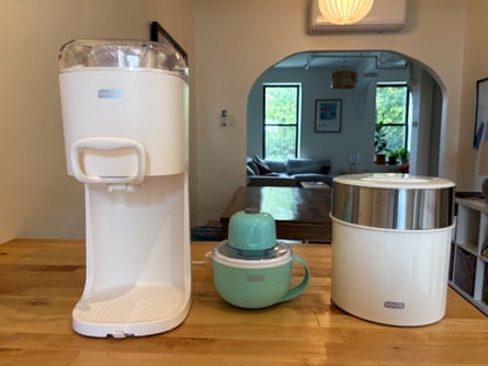 A Dash Soft Serve Ice Cream Machine, Dash My Mug Ice Cream Maker, and Dash Deluxe Gelato & Ice Cream Maker lined up on a kitchen table