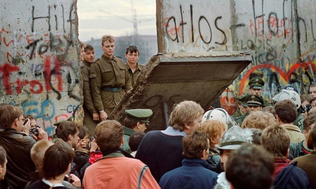West Berliners crowd in front of the Berlin Wall in November 1989 as they watch East German border guards demolishing a section.