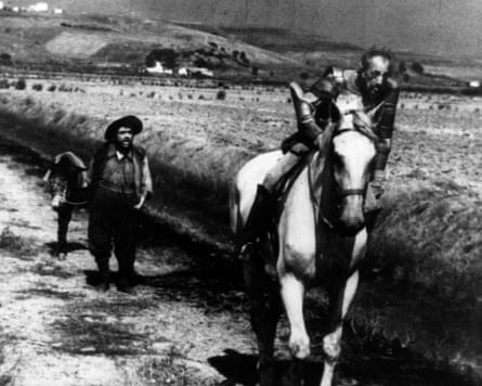 Don Quixote on horseback and Sancho Panza walking behind in a scene from Orson Welles’ footage