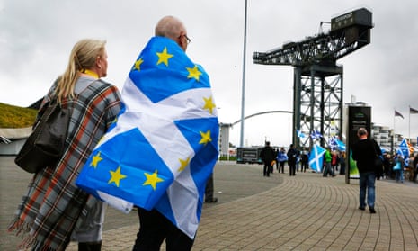 A man wrapped in a hybrid Scottish and EU flag