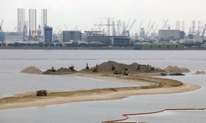 Trucks carry sand at the Forest City development in Johor Bahru, Malaysia
