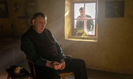 Brendan Gleeson as Colm sits indoors, ignoring Colin Farrell as Pádraic at the window in The Banshees of Inisherin