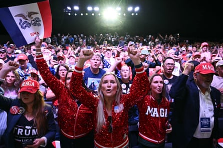 Supporters cheer with raised fists at a Trump campaign rally in Iowa