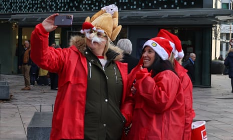 Workers for the Crisis homeless charity take a selfie as a choir sings Christmas songs in Cardiff on 20 December, 2022.