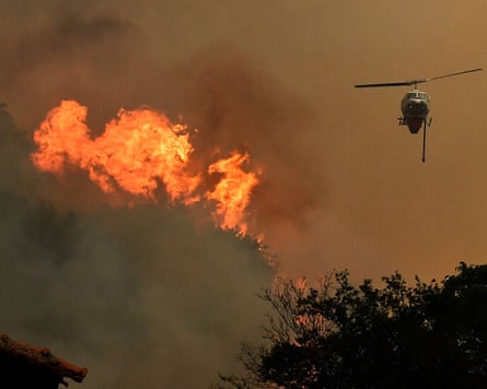 A firefighting helicopter battles a fire that broke out in a forested area in Feneos, Corinth, Peloponnese
