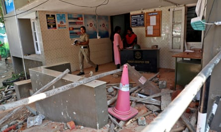 A policeman walks past the rubble after a clash with protesters at a police station near the proposed Vizhinjam port in Kerala, India, on November 28.