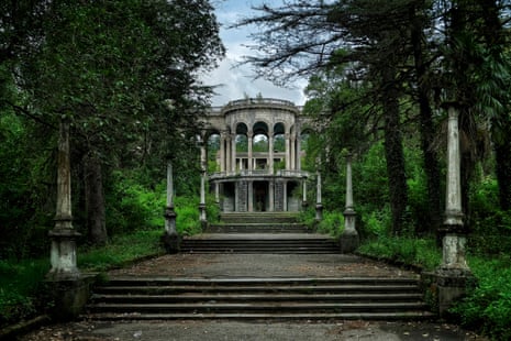 A long paved path with small flights of steps leads to a large arched monument