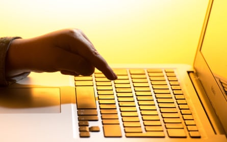 A hand poised over a laptop on a table