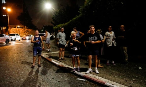 People look on at the scene where a rocket fell in Haifa.