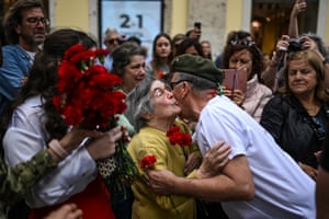 Ninety-year-old Celeste Caeiro, who handed red carnations to the military taking part in the Portuguese revolution on 25 April 1974, greets a former soldier during a military parade to celebrate the anniversary on Thursday