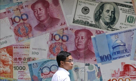 a man passes a billboard displaying oversize yuan notes