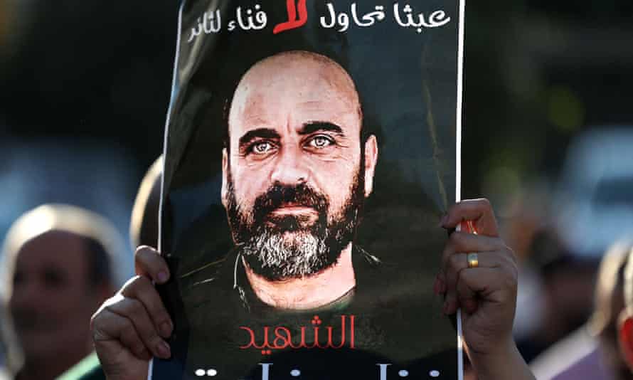 An image of Nizar Banat is held aloft as Palestinians rally in Ramallah city in early August, denouncing the Palestinian Authority following his violent arrest and death.