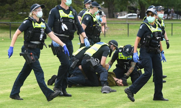 Police arrest protesters during an anti-vaccination rally in Melbourne, Victoria. The national rollout of the Pfizer vaccine will begin on Monday