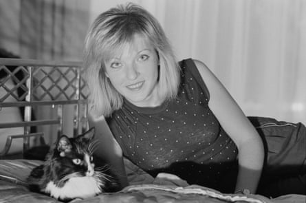 A blond woman in a sleeveless dress with a cat