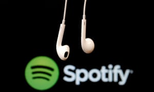 Headphones in front of a logo of online music streaming service Spotify