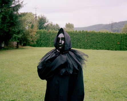 Matvii dressed in black, wearing a black hood and white face mask