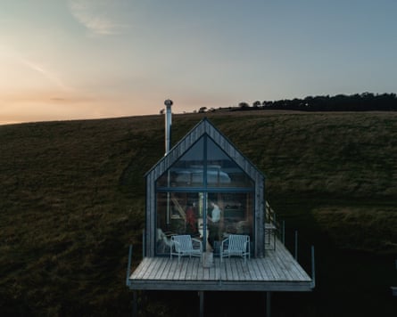 Modern hut with decking on hillside at dusk
