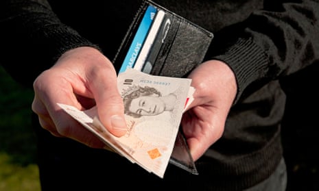Man holding wallet and ten pound notes England UK
