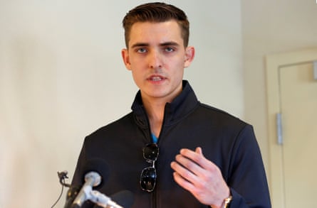 man in black speaks into microphones at podium