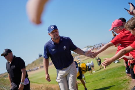 Bryson DeChambeau taps hands with spectators