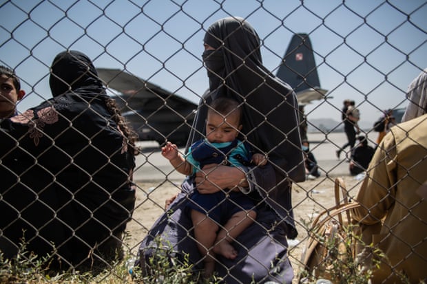 A woman with her child at Kabul airport wait for their flight, on 25 August 2021.