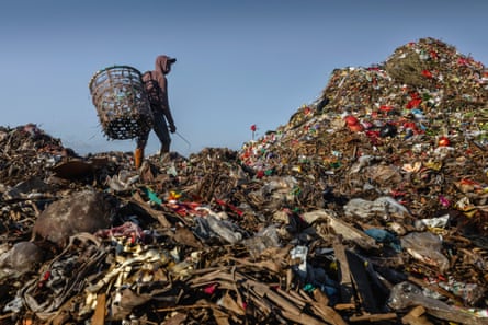 A worker on top of a mountain of rubbish in Indonesia