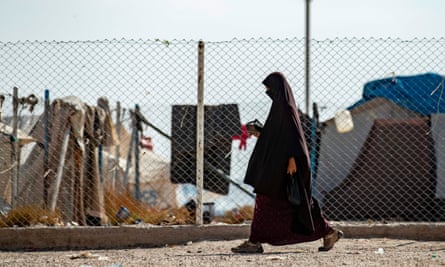 A woman walking near a fence at al-Hawl camp in Syria in October 2019