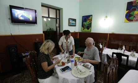 Tourists eat at a <em>paladar</em> or home restaurant in the town of Cienfuegos.