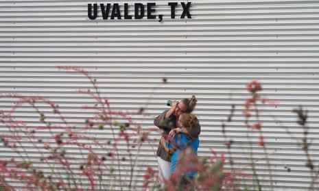 A woman cries and hugs a young girl outside a civic centre where grief counselling will be offered in Uvalde, Texas