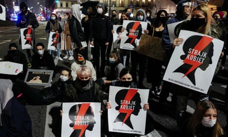 Demonstrators holding ‘women’s strike’ placards block a street in Warsaw during a protest over the constitutional tribunal’s abortion ruling.