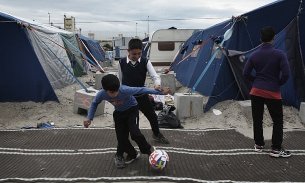 boys play football in the Calais refugee camp