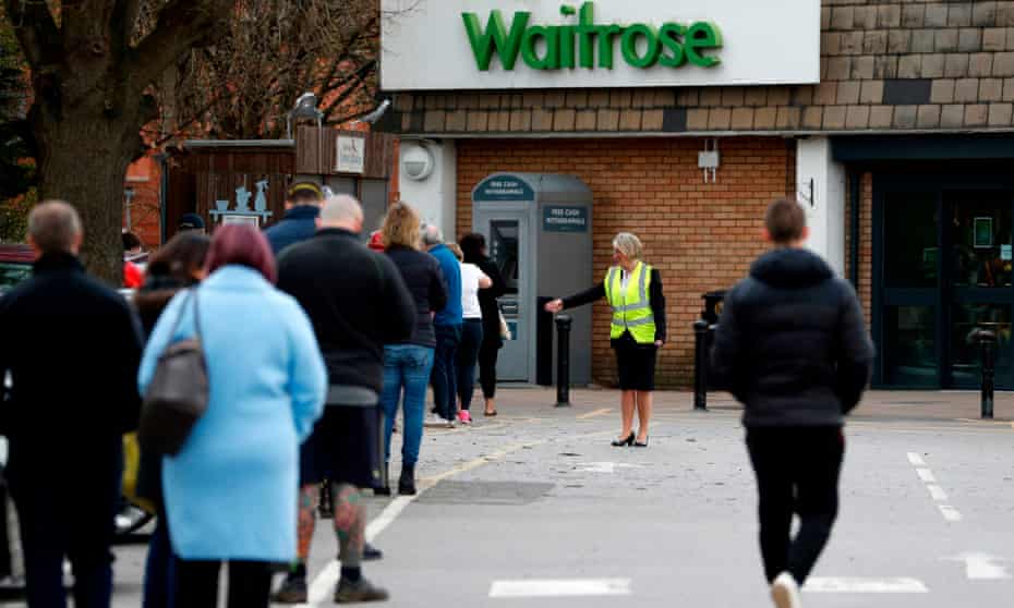 Shoppers queuing outside a Waitrose supermarket in Frimley, Surrey.