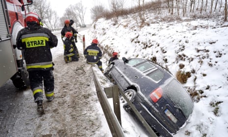 Firefighters try to free a snow-stricken car from a ditch in Babice, Poland.