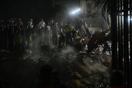 Rescue workers and volunteers search through the rubble of a collapsed building in Caracas.
