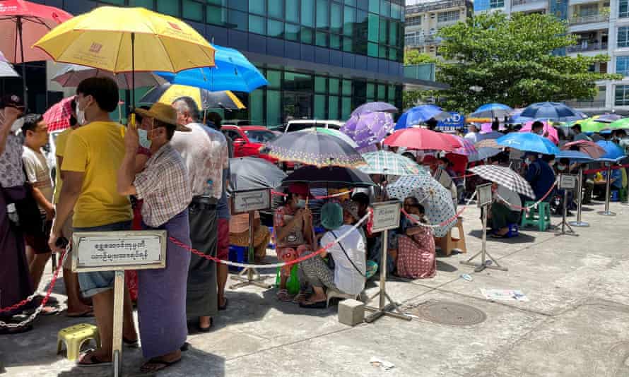 People queue outside a bank to withdraw cash in Yangon last year