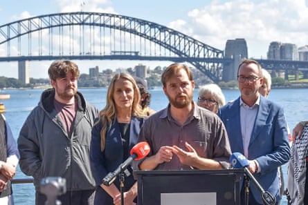 Zack Schofield speaking to media, with the Sydney Harbour Bridge in the background