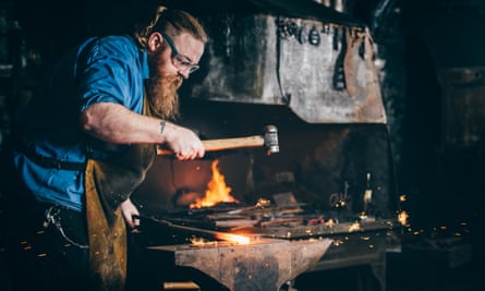 A burly, bearded man working with a hammer and anvil
