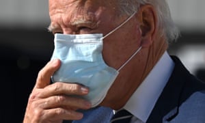 Joe Biden adjusts his double mask as he walks off the plane in Detroit, Michigan, on October 16, 2020.