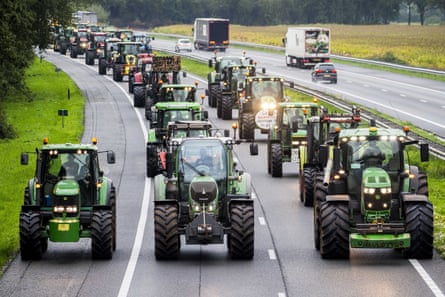 Two lanes of a highway are seen to be full of tractors