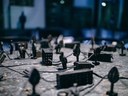 Small figurines of buildings and people connected by rope