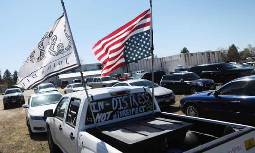 A truck with an upside-down American flag is parked in the parking lot during a church service organized by Ammon Bundy.