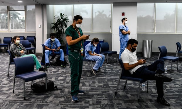 Students and doctors of Medical Science listen to the governor of Florida during a press conference to address the rise of coronavirus cases in the state, at Jackson Memorial Hospital in Miami, on July 13, 2020