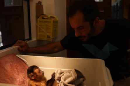 A man looks down at a monkey