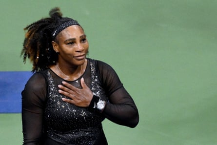 Serena Williams, wearing a black sparkling tennis dress, holds her hand to her heart towards the audience at the US Open in 2022