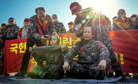 South Korean veteran marines shave their heads in protest against the president, outside the presidential office on 5 December in Seoul.