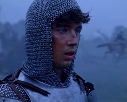 Troye Sivan in chainmail and armour, face bloodied, looks off into misty surroundings