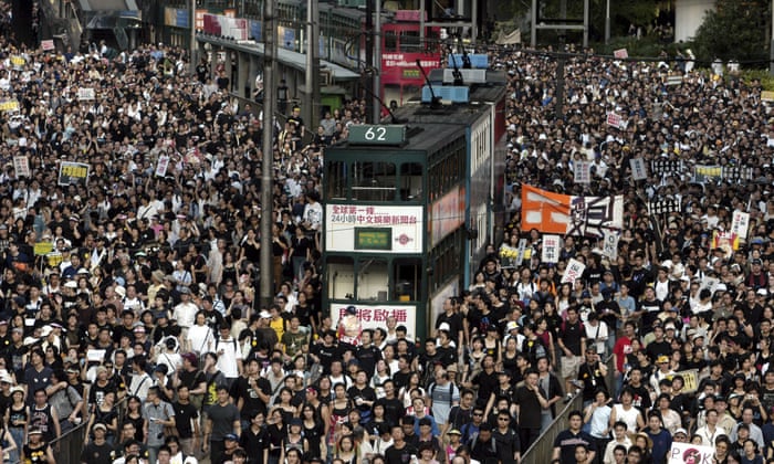 Tens of thousands of people pack a Hong Kong street while marching to Hong Kong government headquarters to protest the Hong Kong government’s plans to enact an anti-subversion bill.